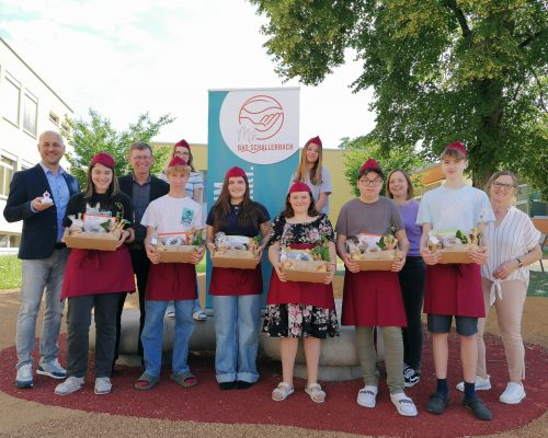 Text zum Bild: Die fleißigen Schüler/innen samt Lehrerinnen Frau Kirchberger und Frau Muggenhumer und Direktor Eibl bei der Übergabe der Geschenkkisterl an Vitalwelt-Chef Phillip Haas (links)